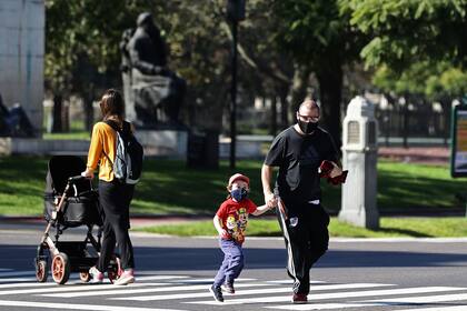 La gente cruza la calle después de que las autoridades permitieron que los niños salieran durante una hora con fines recreativos, en medio del bloqueo impuesto contra la propagación del nuevo coronavirus en Buenos Aires, el 16 de mayo de 2020