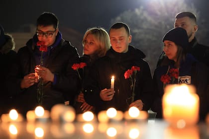 La gente deposita flores y enciende velas en memoria de las víctimas del ataque con armas de fuego en un concierto de Moscú en el centro de Simferopol, Crimea, el 22 de marzo de 2024. 