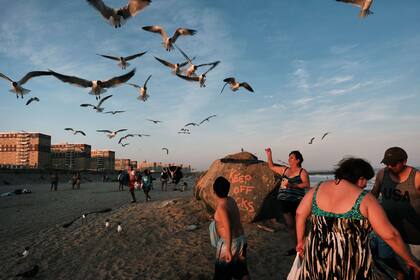 La gente disfruta de una cálida noche en Rockaway Beach el 19 de julio de 2022 en la ciudad de Nueva York
