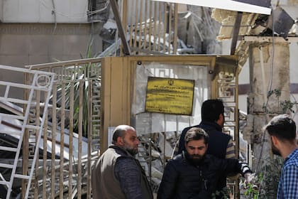 La gente espera afuera de un edificio anexo a la embajada iraní un día después de un ataque aéreo en Damasco el 2 de abril de 2024.