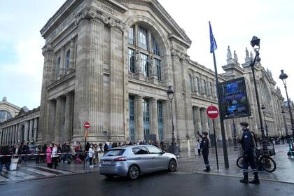 La gente espera detrás de la cinta policial fuera de la estación de tren Gare du Nord, el miércoles 11 de enero de 2023 en París.