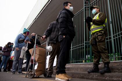 La gente hace cola en un mercado popular en Santiago, el 22 de junio de 2020, en medio de la pandemia de coronavirus