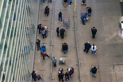La gente hace fila en East River Plaza para comprar en Costco y Target el 8 de abril de 2020 en la ciudad de Nueva York. Las empresas que permanecen abiertas continúan alentando el distanciamiento social