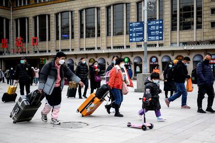 La gente llega a la estación de tren de Pekín el 27 de enero de 2021