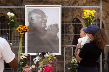 La gente lleva flores a la Catedral de St. Georges, donde se instaló un Muro en Recuerdo de Desmond Tutu, Premio Nobel de la Paz, después de la noticia de su muerte, el 26 de diciembre de 2021 en Ciudad del Cabo. 