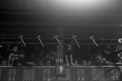 La gente mira el sacrificio de búfalos desde el Lakian conteniendo el cuerpo de Nenek Berta, durante el ritual funerario o ceremonia de Rambu Solo en su honor en la aldea de Siguntu.