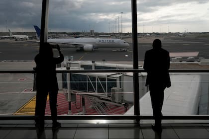 La gente mira un vuelo de United Airlines que sale hacia Newark, NJ, en el aeropuerto Leonardo Da Vinci de Fiumicino, cerca de Roma, el lunes 8 de noviembre de 2021.