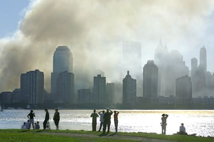 La gente observa desde Jersey City, Nueva Jersey, mientras el humo se eleva desde el bajo Manhattan