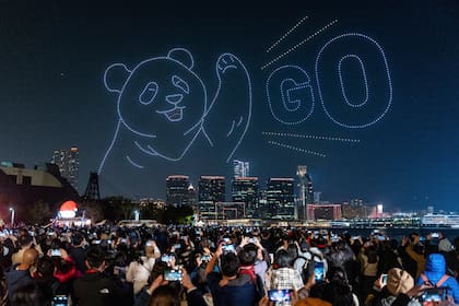 La gente observa el espectáculo de drones con temática de pandas en el puerto Victoria, en Hong Kong