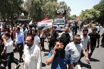 La gente participa en una protesta cerca de la Embajada de Turquía en Bagdad