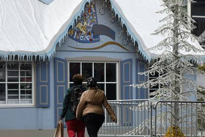 La gente pasa por un puesto que está instalado para el mercado navideño en Essen, Alemania occidental, el 29 de octubre de 2020, durante la pandemia del nuevo coronavirus