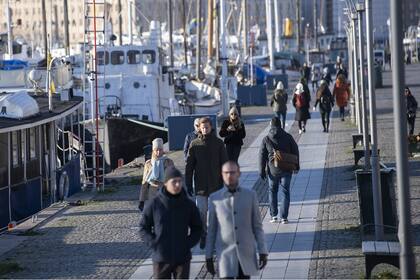 La gente pasea a lo largo del muelle de Standvagen en Estocolmo, Suecia, el 20 de noviembre de 2020, en medio de la pandemia de coronavirus