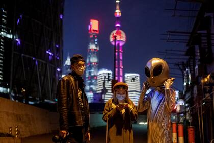 La gente posa junto a un disfrazado de "alien" en Shanghai