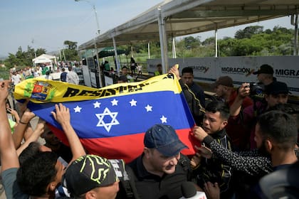 La gente protesta en el puente fronterizo Internacional Simón Bolívar entre Colombia y Venezuela, en las afueras de Cúcuta