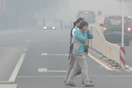La gente que no tiene barbijos se tapa la cara para respirar