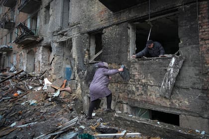 La gente recoge sus pertenencias en una casa dañada después del bombardeo ruso en la ciudad de Vyshgorod, en las afueras de la capital, Kiev, Ucrania, el jueves 24 de noviembre de 2022.(Foto AP/Efrem Lukatsky)