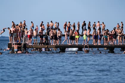 La gente salta de un embarcadero en Malmo, Suecia, el 25 de junio de 2020, durante una ola de calor con temperaturas de más de 30 grados
