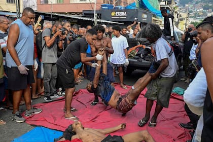 La gente se concentró alrededor de los muertos en la plaza en Río de Janeiro
 (Photo by Pablo PORCIUNCULA / AFP)