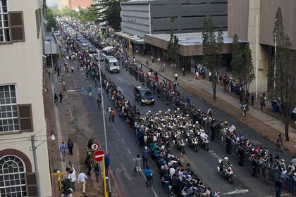 La gente se dispone a la vera del camino para ver pasar el cortejo fúnebre de Nelson Mandela en las calles de Pretoria