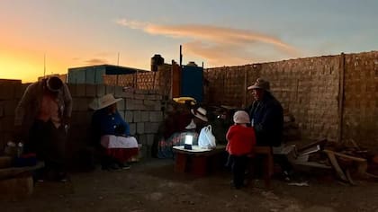 La gente se prepara para cenar iluminados apenas por una linterna.
