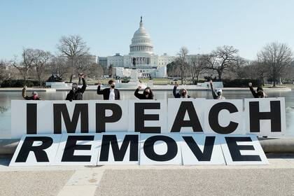 Gente reunida en el Capitolio manifestándose en favor al juicio político contra Trump