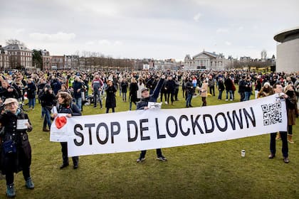 La gente se reúne en la Museumplein de Ámsterdam durante una ceremonia contra el bloqueo impuesto para frenar la propagación de la pandemia del coronavirus y la política del gobierno saliente, el 21 de enero de 2021