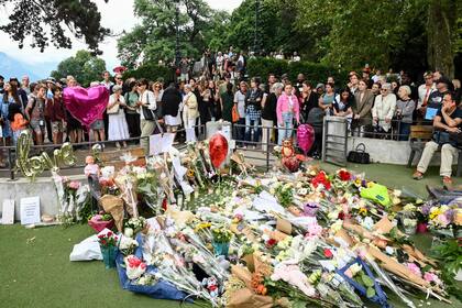 La gente se reúne para depositar flores para las víctimas de un apuñalamiento que ocurrió el día anterior en el parque 'Jardins de l'Europe' en Annecy, Alpes franceses, el 9 de junio de 2023