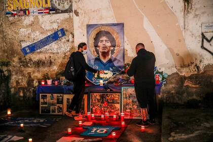 La gente se reúne y enciende velas para honrar a la leyenda del fútbol Diego Maradona, en el popular barrio "Quartieri Spagnoli", en Nápoles