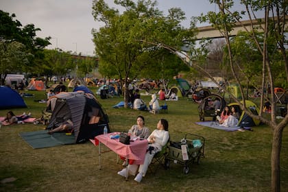 La gente se sienta en un parque en Seúl, Corea del Sur, el 1 de mayo de 2020