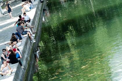 La gente se sienta orillas del Canal Saint-Martin, en París; los meteorólogos dicen que los europeos sentirán un calor abrasador esta semana con temperaturas que se elevarán hasta los 40 grados centígrados