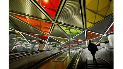 La gente sube a las escaleras mecánicas en la estación de metro Sretensky Bulvar en Moscú, Rusia