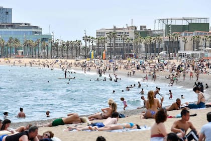 La gente toma el sol en la playa de la Barceloneta, en Barcelona