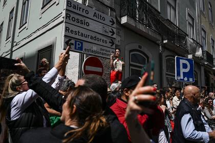 La gente toma fotos al paso del desfile por el 50 aniversario de la Revolución de los Claveles en Lisboa   