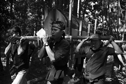La gente transporta el ataúd de Ne Siang para ser colocado en el Lakian durante el inicio del ritual funerario o la ceremonia de Rambu Solo en su honor en el pueblo de Bua Tallulolo.