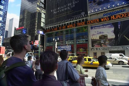 La gente ve pasar las noticias en Times Square sobre los ataques terroristas al World Trade Center en Nueva York, el martes 11 de septiembre de 2001