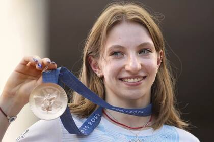 La gimnasta rumana Ana Barbosu sonríe junto a la medalla de bronce de la prueba de piso de los Juegos Olímpicos de París, que recibió en una ceremonia en Bucarest el viernes 16 de agosto del 2024