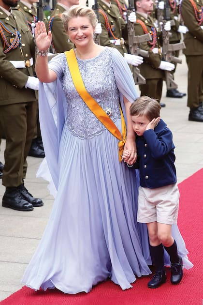 La Gran Duquesa camina por las calles de Luxemburgo llevando de la mano a su hijo mayor y heredero del trono, que se muestra aturdido por la música