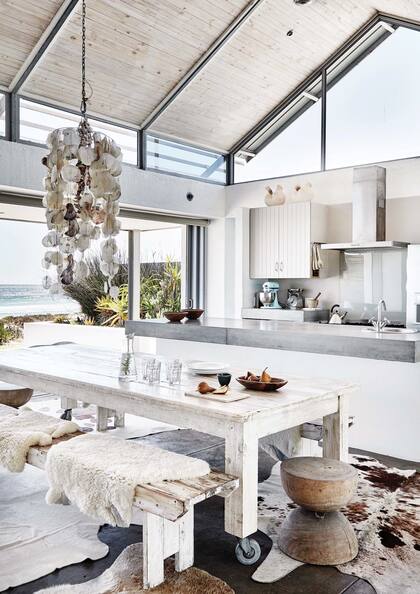 La gran mesa de comedor con ruedas se puede trasladar fácilmente afuera. En la misma sintonía, dos simples bancos resuelven asientos para una docena de comensales.