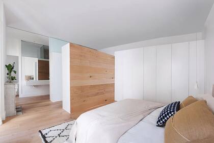 El dormitorio principal recibe luz natural del pulmón de manzana. Tiene el baño incorporado y un vestidor en forma de L con el fondo que da a la cama revestido en teca.