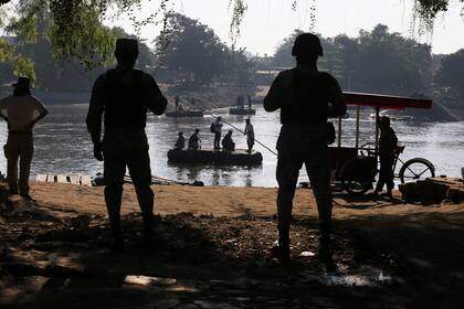 La Guardia Nacional de México vigila el río Suchiate, donde los lugareños transportan carga y personas entre México y Guatemala, cerca de Ciudad Hidalgo. (AP Foto/Marco Ugarte, Archivo)