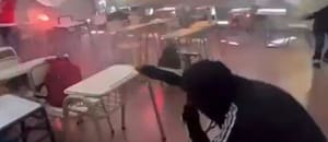 Un grupo de alumnos realiza una ”guerra de bengalas" dentro de un aula