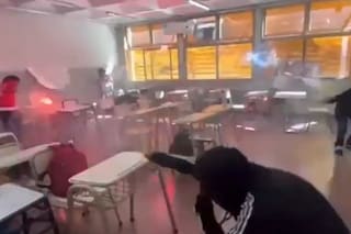 Un grupo de alumnos realiza una ”guerra de bengalas" dentro de un aula