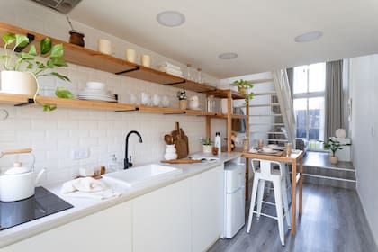 La heladera tamaño frigobar se ubicó bajo la mesada de Silestone ‘Blanco Norte’ (Castro Hermanos). Muebles de cocina (carpintero Mario). Banquetas ‘Tolix’ (May Deco). Macetas y plantas (Ciudad Naturaleza).