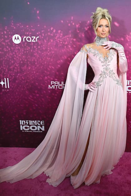 La heredera del imperio Hilton deslumbró con un vestido de Tony Ward íntegramente bordado con cristales, de escote profundo adornado con pedrería, una capa vaporosa off shoulder y abertura lateral. Completó el look con guantes rosa a juego y una maxigargantilla