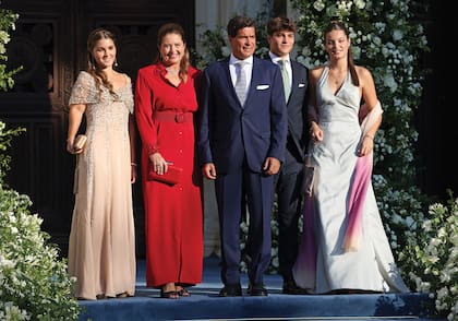 La hermana de Teodora, Alexia de Grecia (con un diseño midi con cuello camisa en rojo en el que destacaban los puños fruncidos y un cinturón con gran hebilla) junto a su marido, Carlos Morales, y sus hijos, Ana María (by Valentino), Carlos y Amelia (con un vestido de su madre).