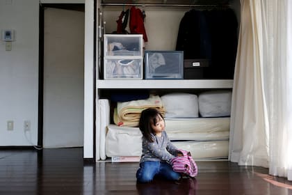 la hija de 3 años de Naoki Numahata juega en el living de su departamento de Tokio