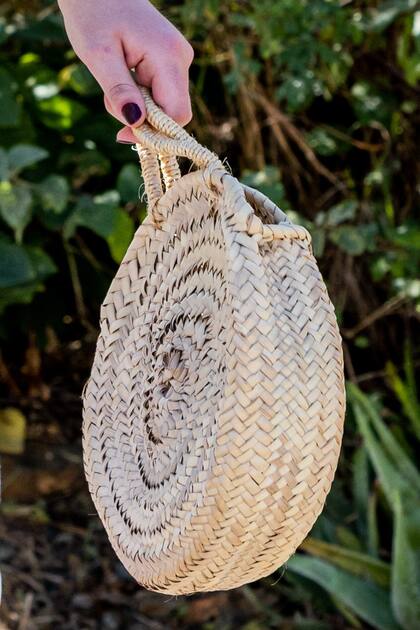 La hija de los reyes de los Países Bajos elige carteras pequeñas. En su viaje por Aruba llevó un bolso de rafia circular.