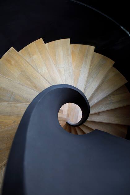 La hipnótica escalera de chapa negra con peldaños en roble (Patagonia Flooring) fue diseñada en colaboración con Juan Trivelloni.