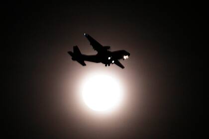 La imagen de un avión se recorta contra la luna en Corea del Sur