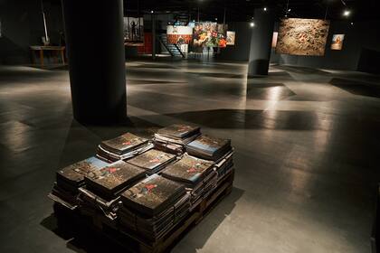 La imagen de una chica que pasea a su perro frente a un centro comercial bombardeado en Kiev ilustra la tapa de la publicación que acompaña la muestra, con fotos que flotan en la sala